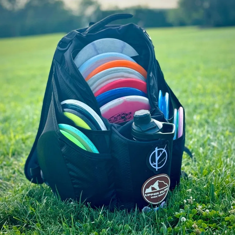 Upper Park Shift disc golf backpack loaded with discs and a water bottle